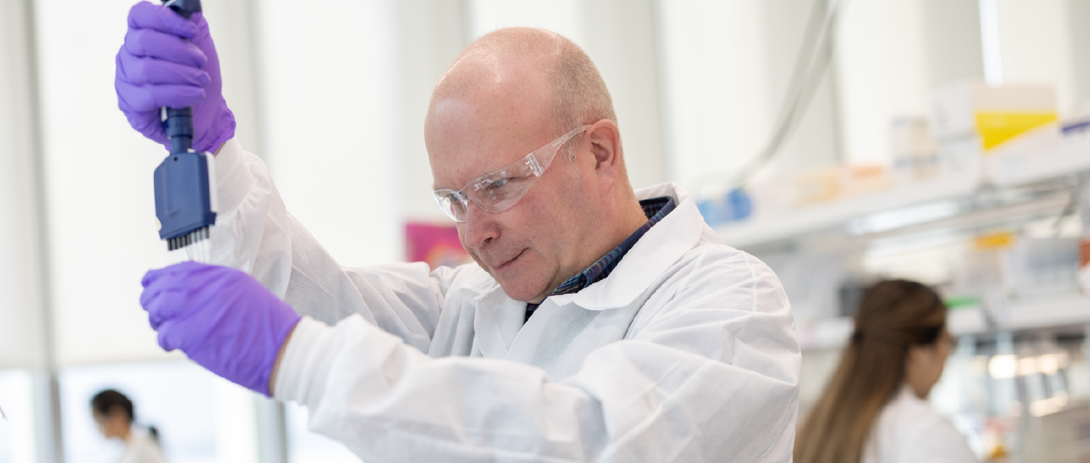 A Lyell lab associate looking through a microscope
